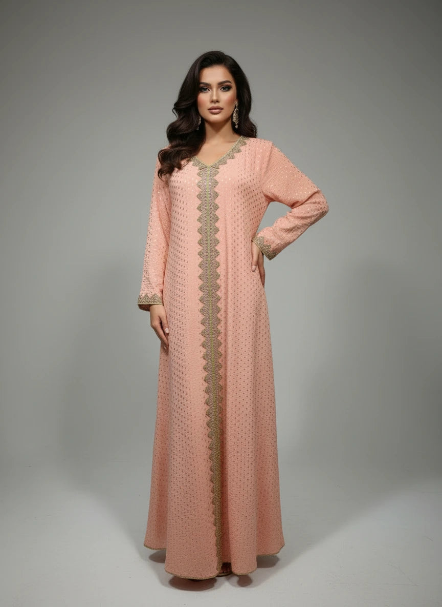 Peach-colored dress with gold embroidery on a mannequin against a white paneled wall.