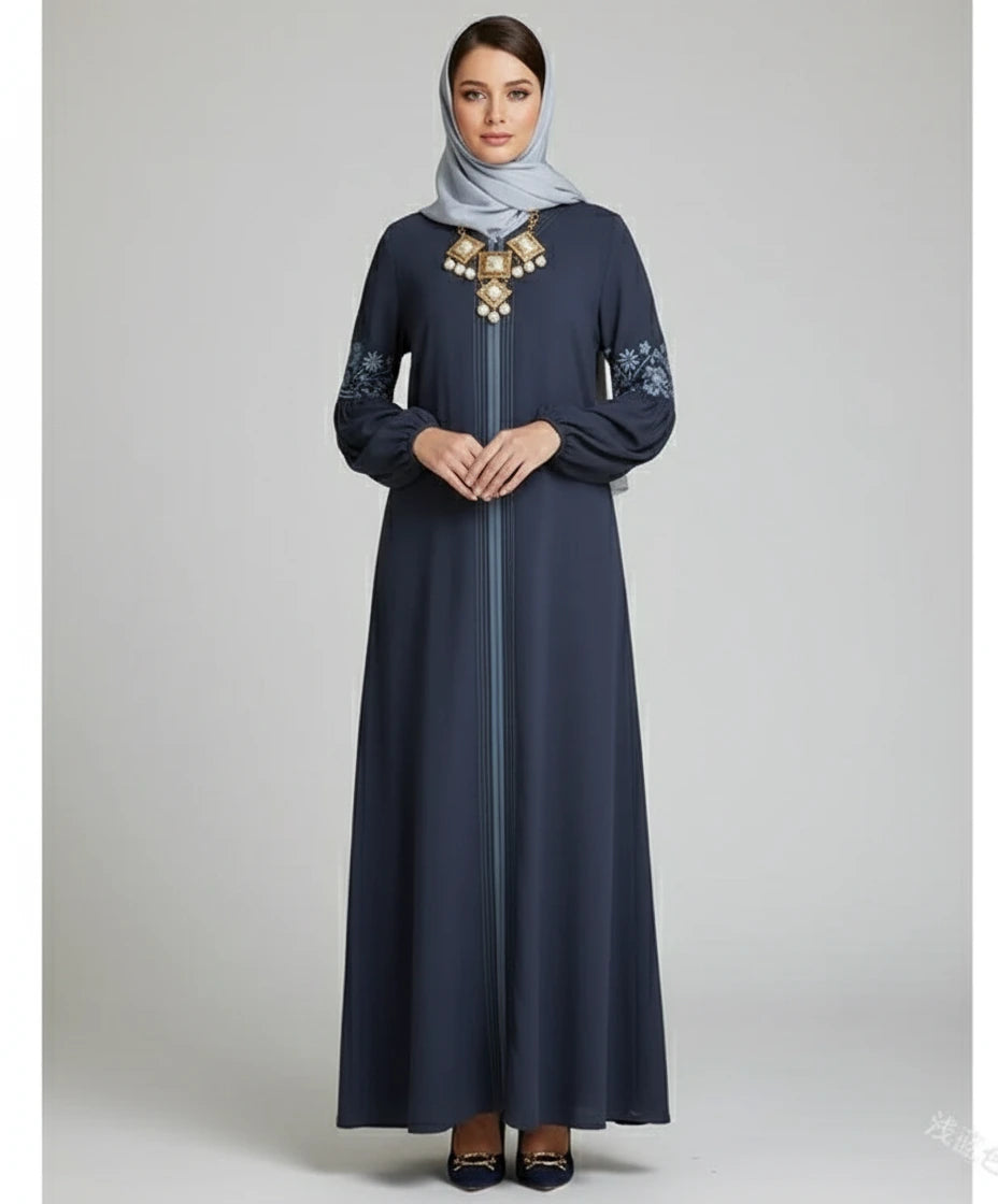 Woman wearing a navy blue dress with gold embroidery on a gray background