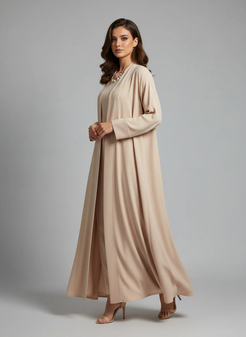 Woman wearing a beige long dress against a gray background