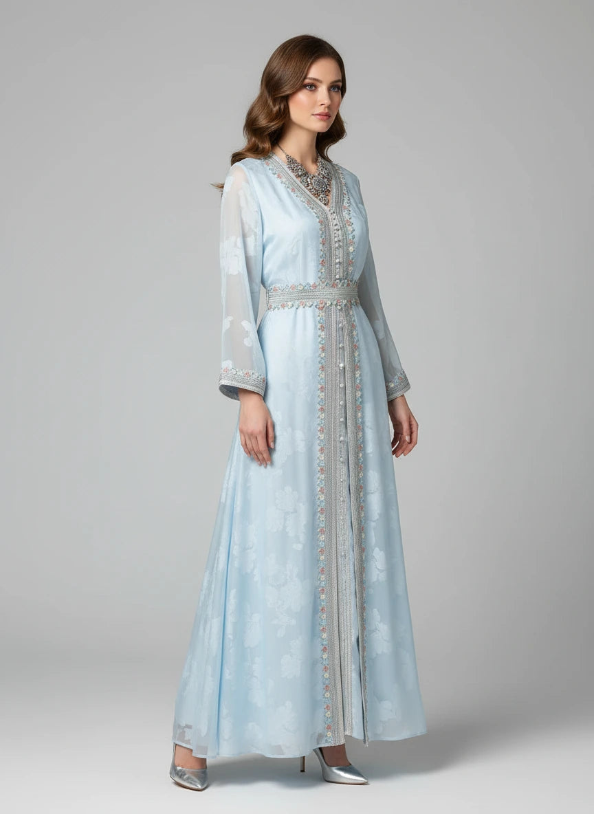 Woman wearing a light blue embroidered dress on a gray background