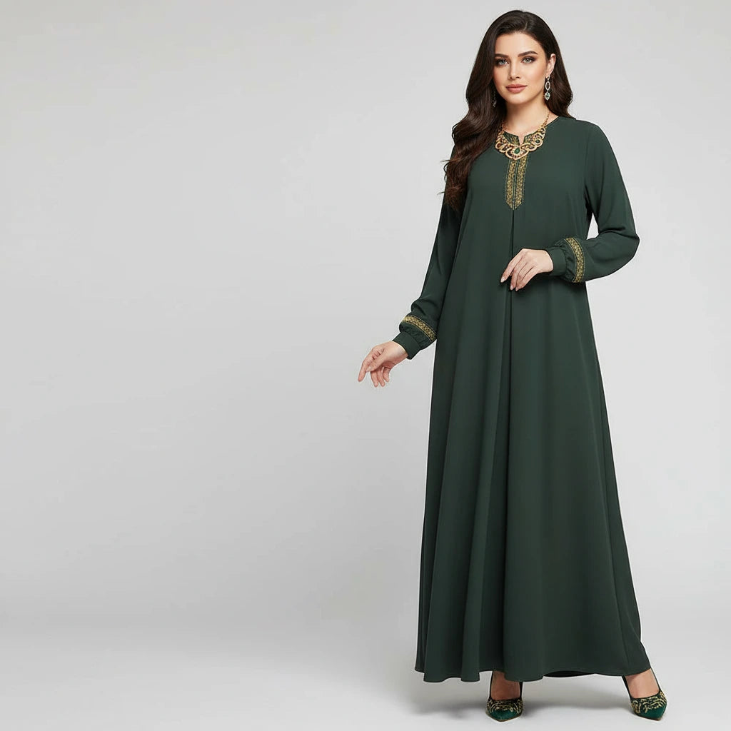 Woman wearing a green dress with gold embroidery on a gray background