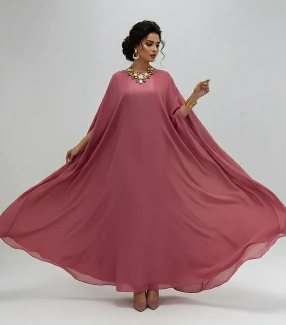 Woman wearing a pink dress with a plain background