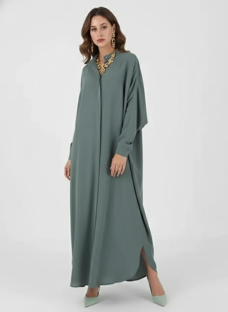 Woman wearing a long green dress holding a white handbag on a white background