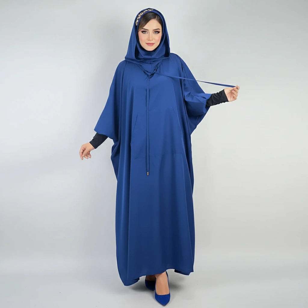 Woman wearing a blue hooded dress against a white background