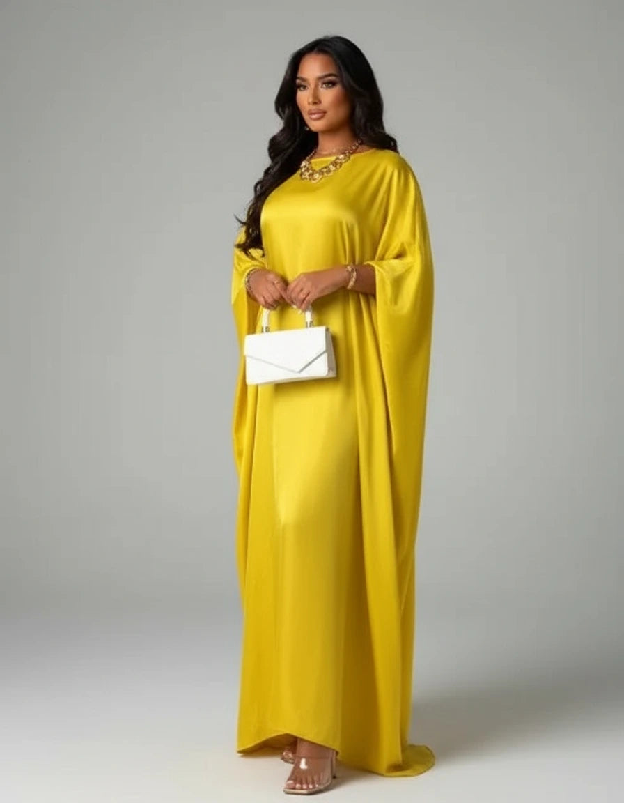 Woman wearing a yellow dress holding a white clutch against a gray background