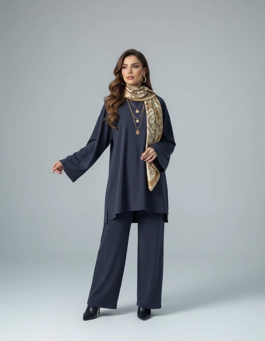 Woman wearing a navy outfit with a beige hijab on a gray background
