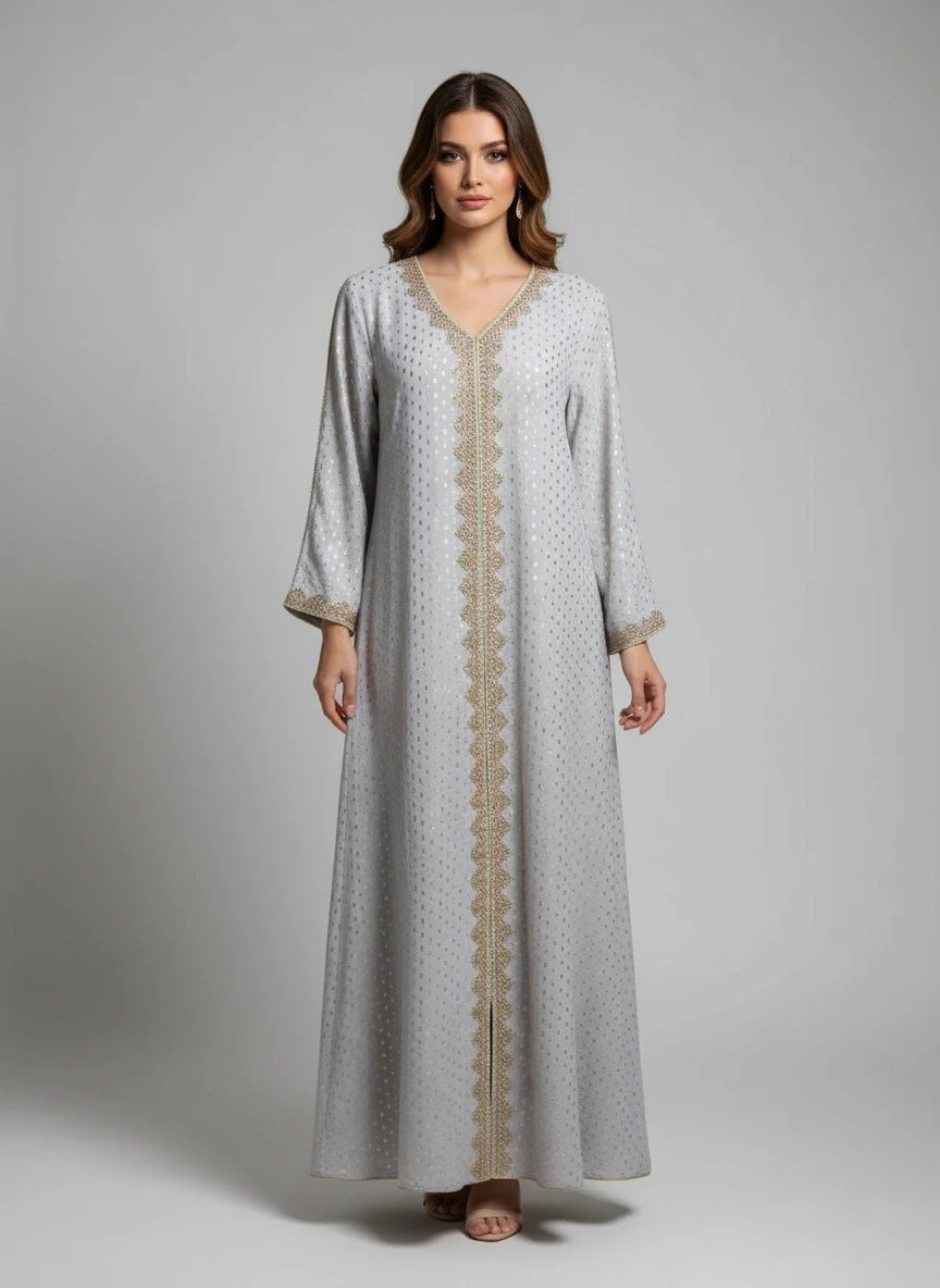 Long, light gray dress with gold trim on a mannequin against a white paneled wall.