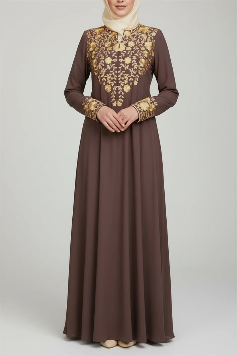 Woman wearing a brown dress with gold embroidery in an outdoor setting
