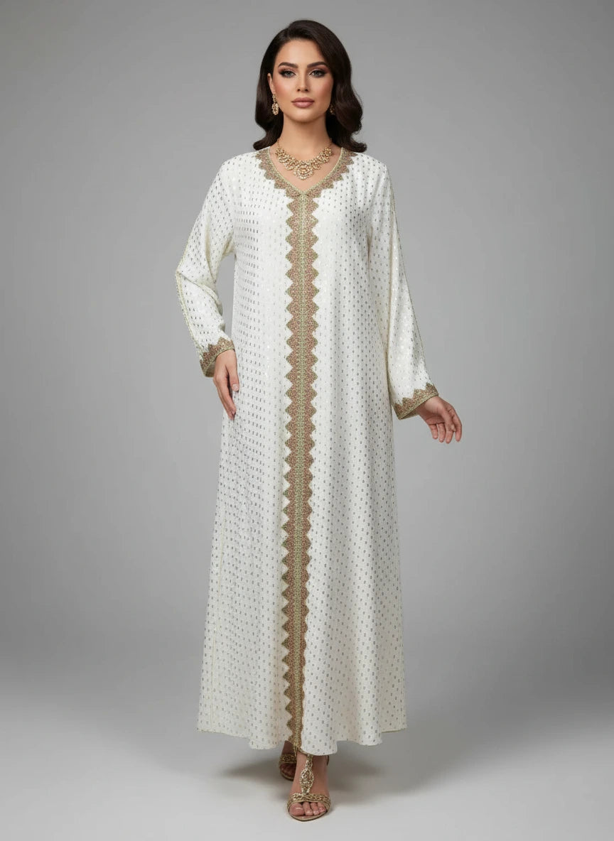 Long white dress with gold embroidery on a mannequin against a gray wall.