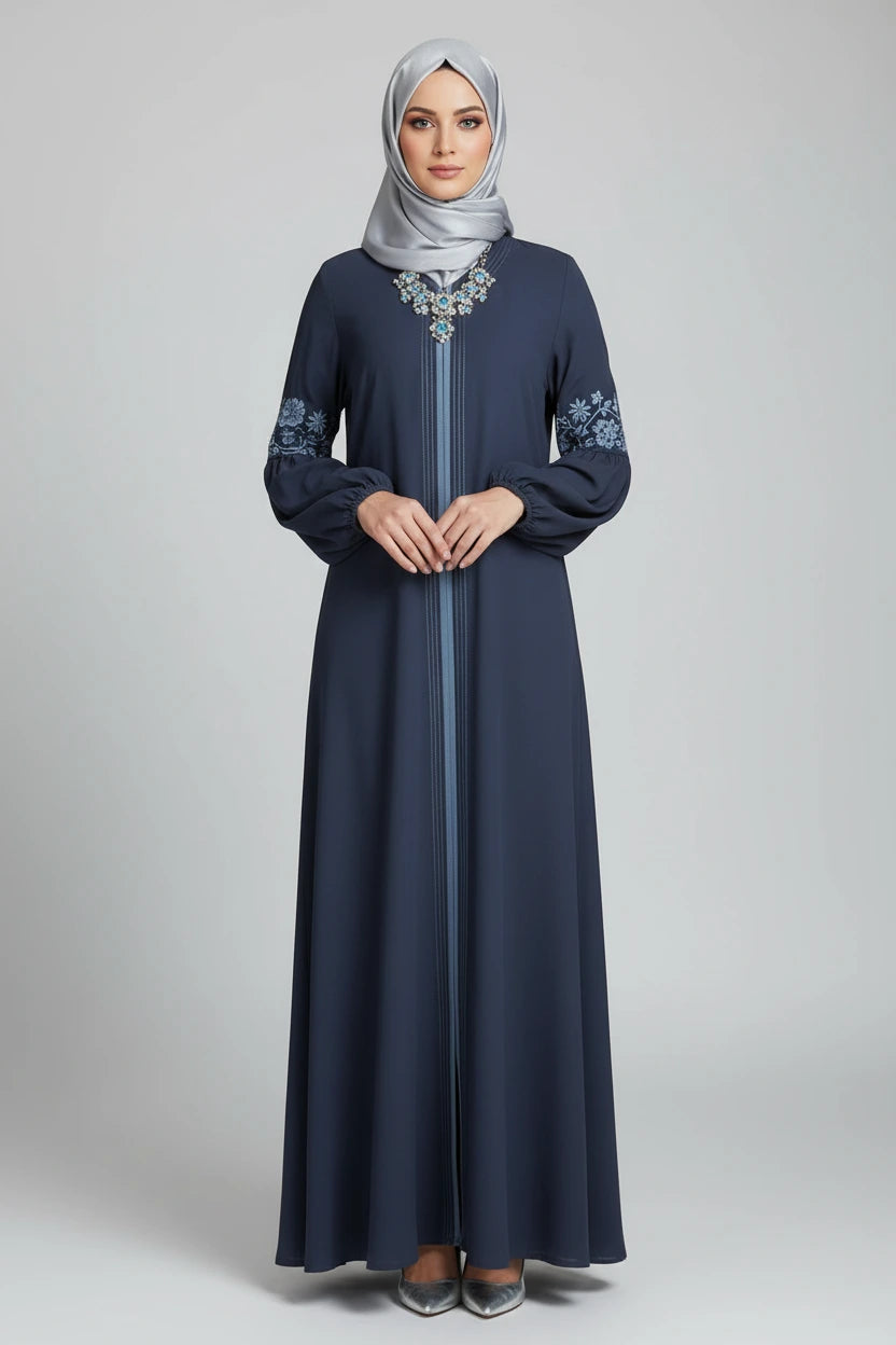 Woman wearing a long dark blue dress with floral patterns on sleeves and cuffs, standing outdoors.