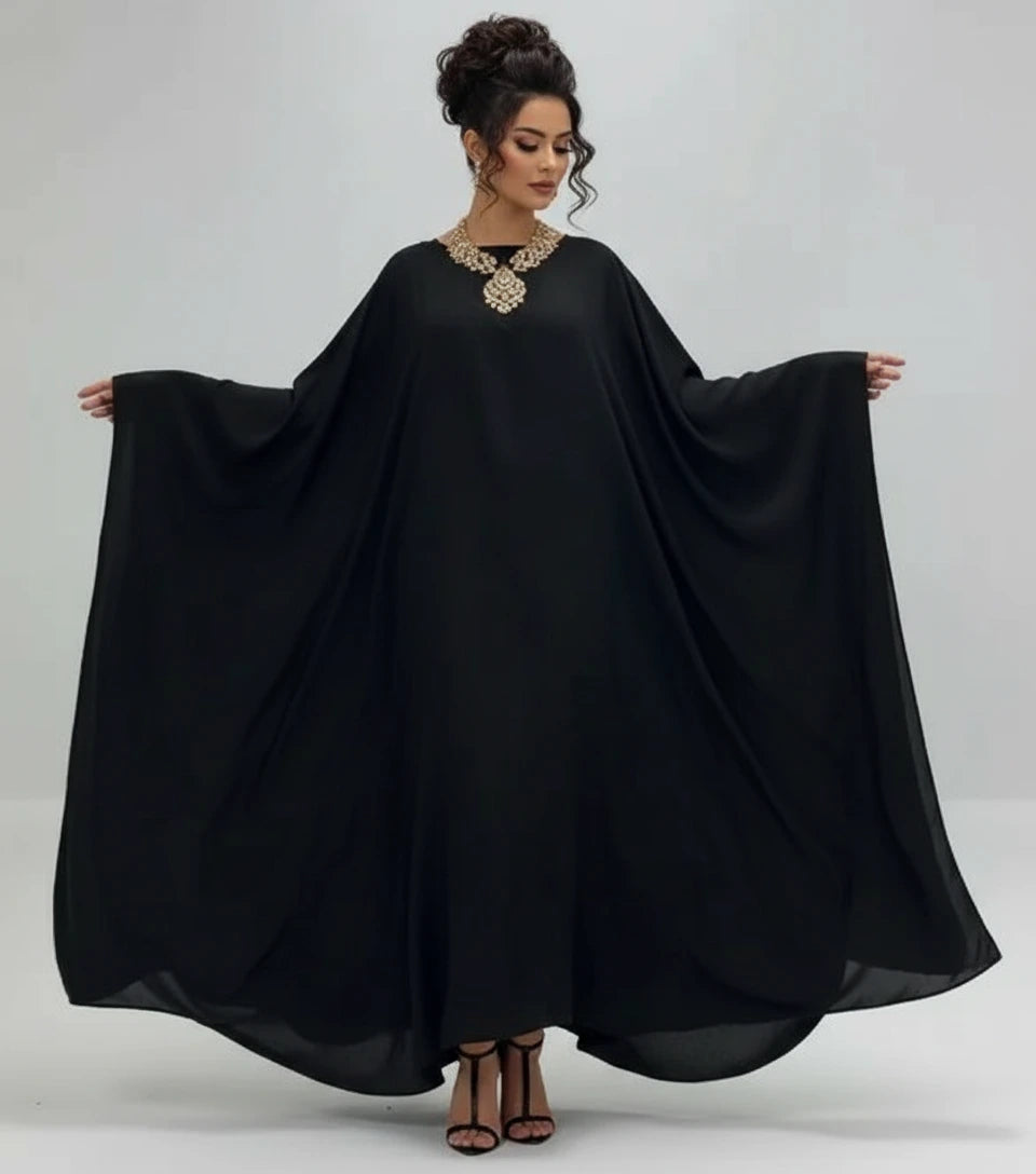 Woman wearing a black flowing dress on a white background