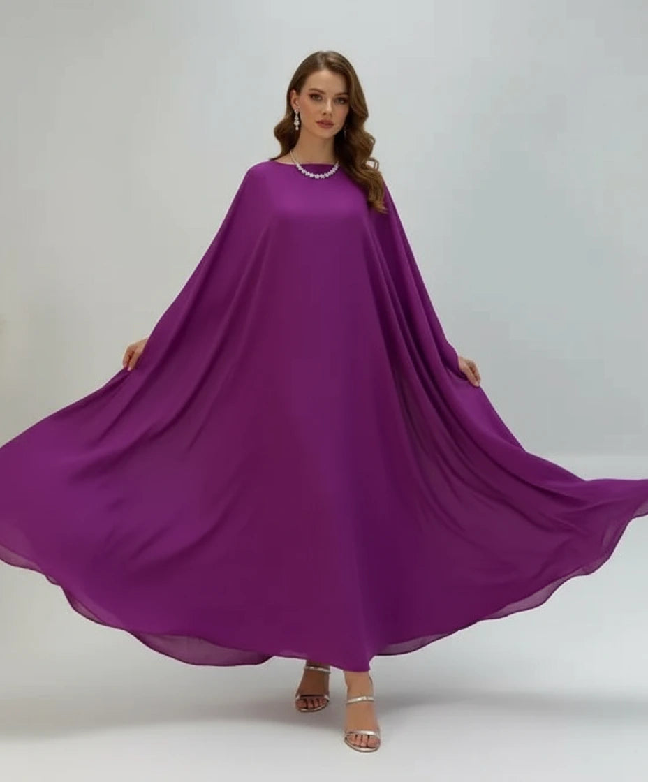 Woman wearing a flowing purple dress on a plain background