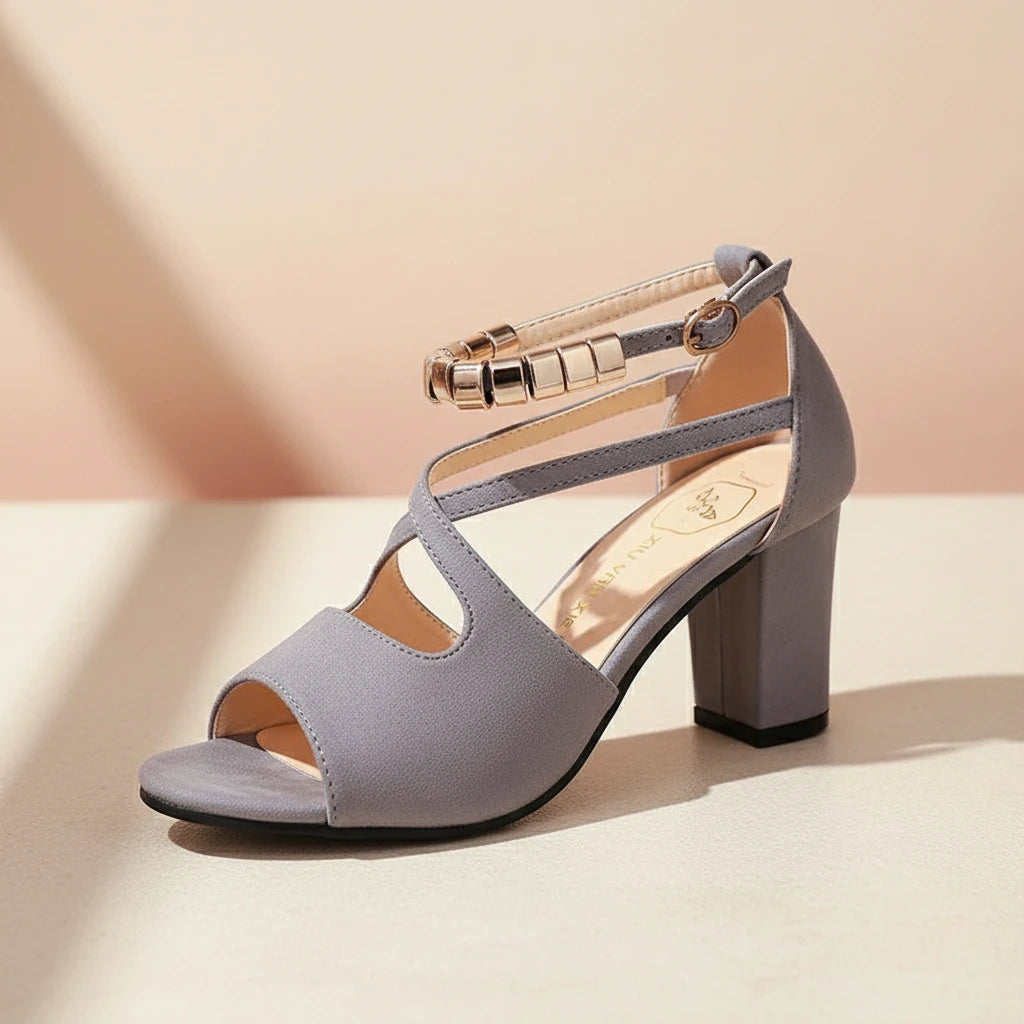 Gray high-heeled sandal with gold straps on a beige background