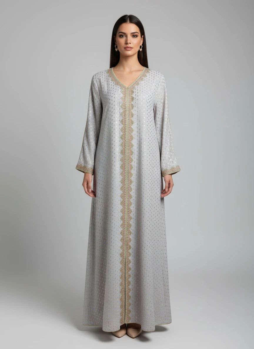 Long, light gray dress with gold trim on a mannequin against a white paneled wall.