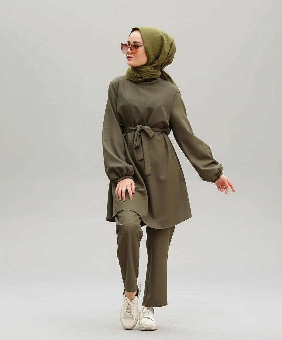 Woman in a green outfit walking outdoors with blurred background