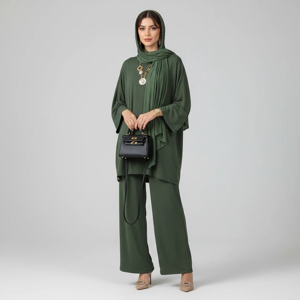 Woman wearing a army green outfit with a beige hijab on a gray background