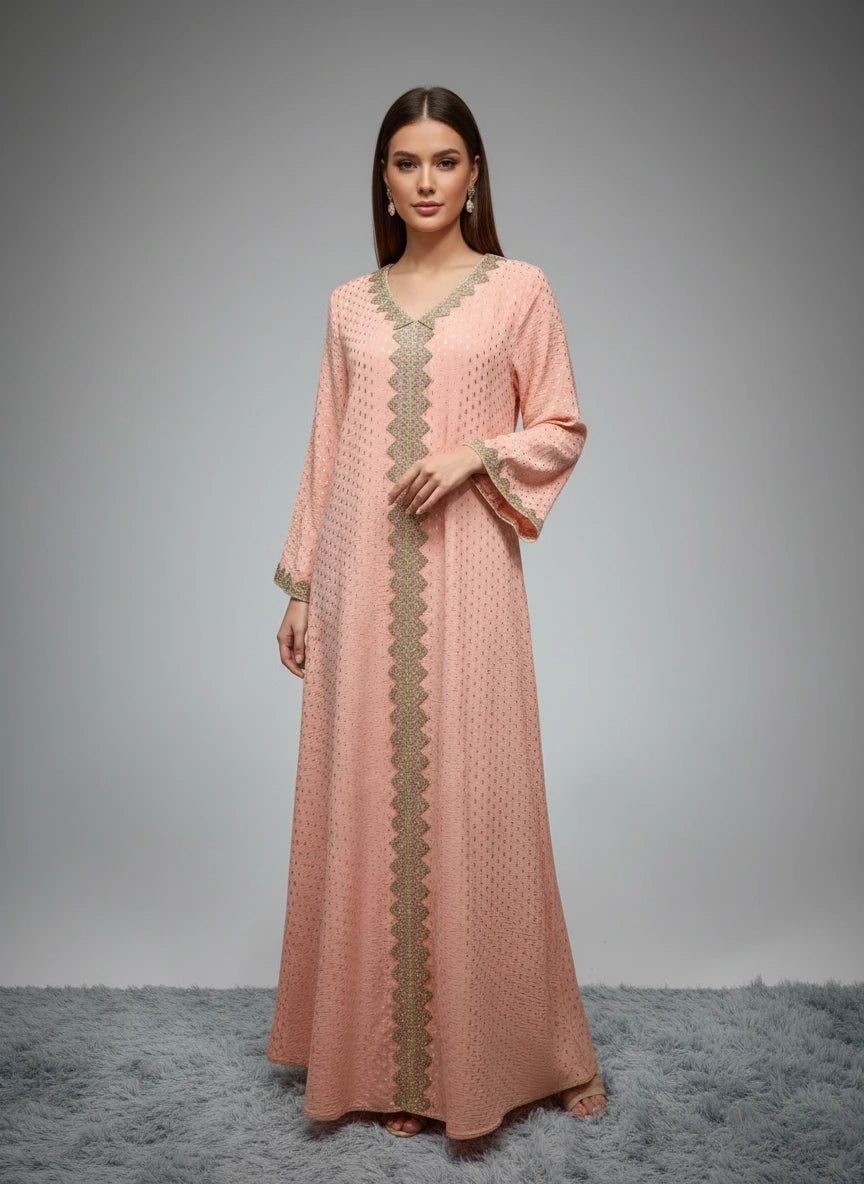 Peach-colored dress with gold embroidery on a mannequin against a white paneled wall.