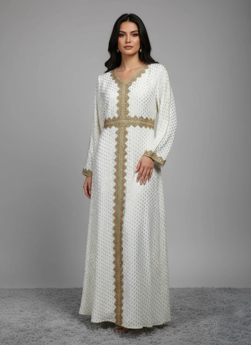Long white dress with gold embroidery on a mannequin against a gray wall.