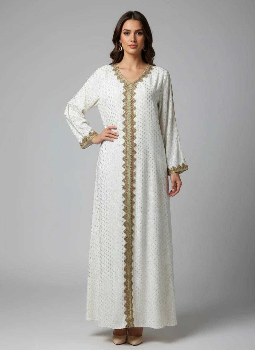 Long white dress with gold embroidery on a mannequin against a gray wall.