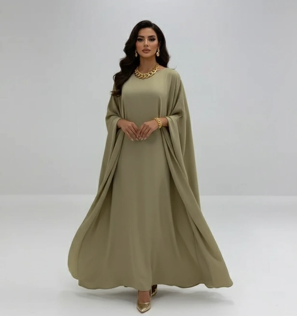Beige dress on a mannequin with a vase of pampas grass on a white background