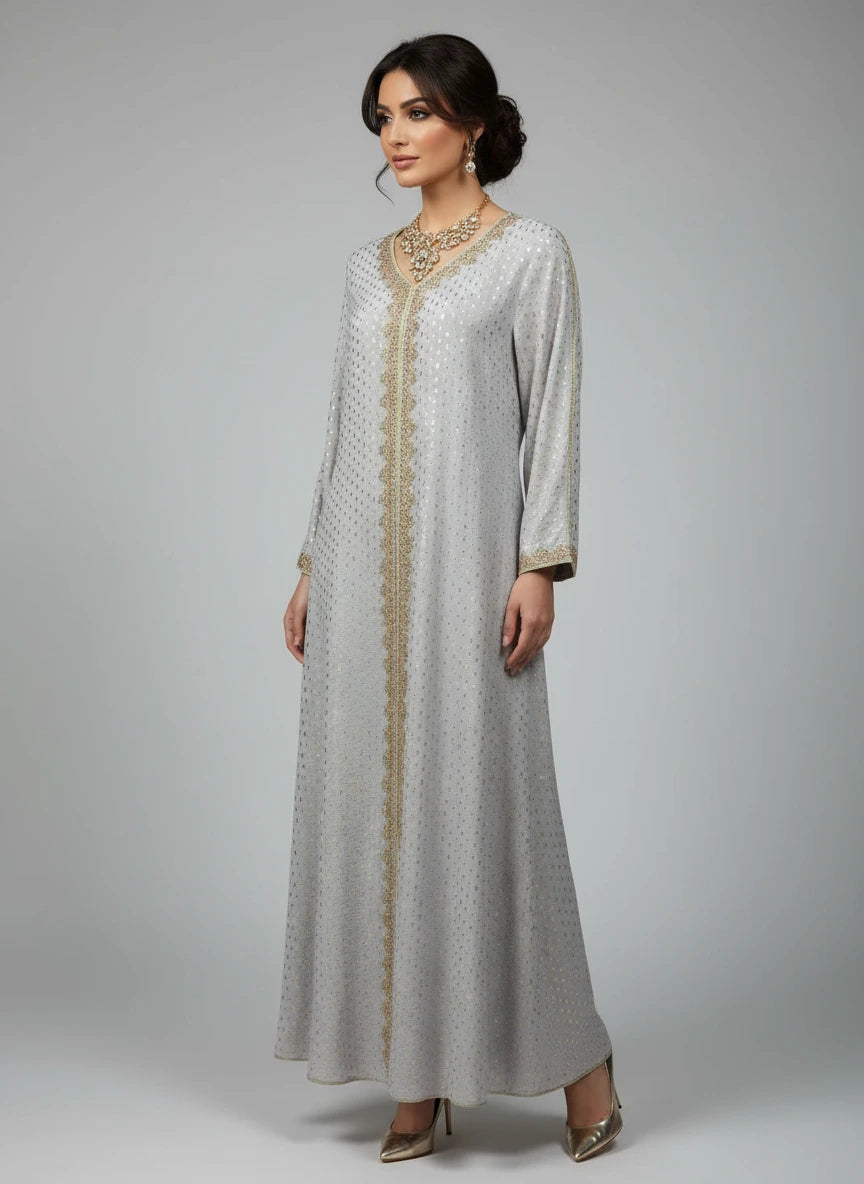 Long, light gray dress with gold trim on a mannequin against a white paneled wall.