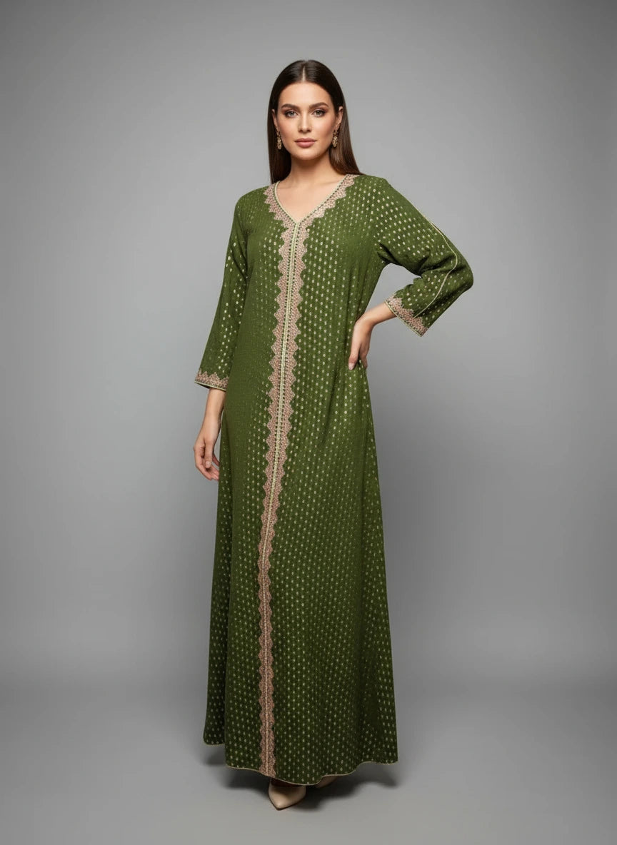 Green dress with beige patterns on a mannequin against a white paneled wall.